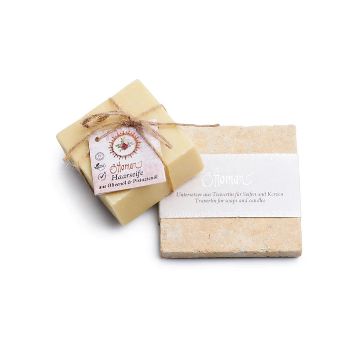 Ein mit einer Schnur zusammengebundenes Stück Naturseife neben einem rechteckigen Tablett aus Travertin aus der Zeit des Osmanischen Reiches – aus dem Set „Travertin-Seifenset mit Naturseife (Kopie)“.