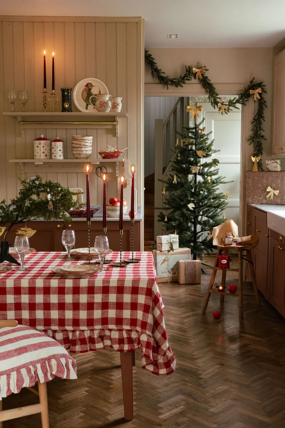 Weihnachtlich geschmückte Stube mit rot karierter Strömshaga-Tischdecke und Tannenbaum